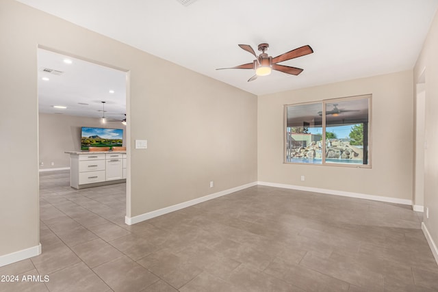 tiled spare room with ceiling fan