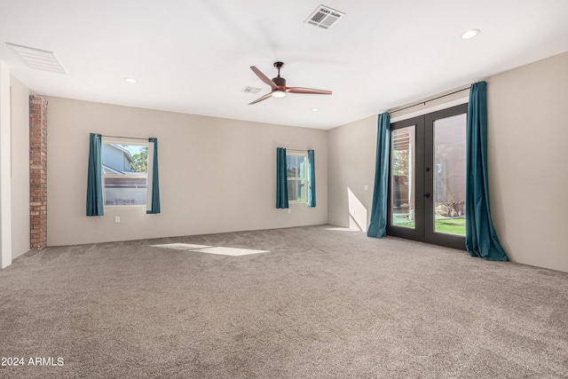 empty room featuring french doors, light colored carpet, and ceiling fan