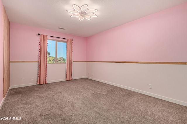 empty room featuring carpet and a textured ceiling