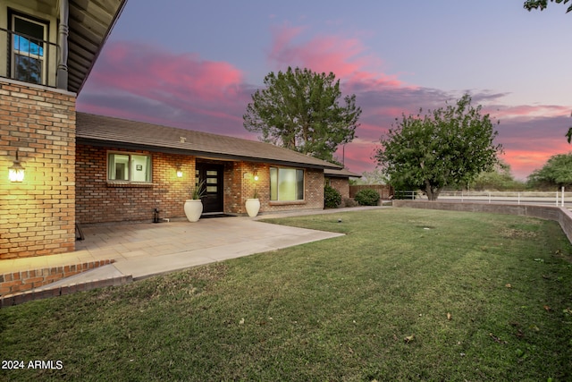 yard at dusk with a patio area