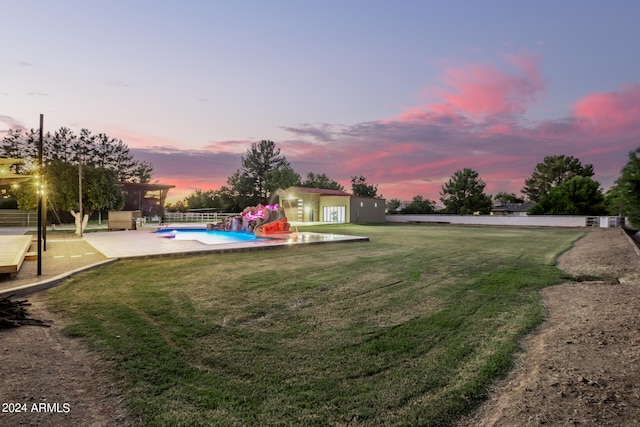 yard at dusk featuring a patio