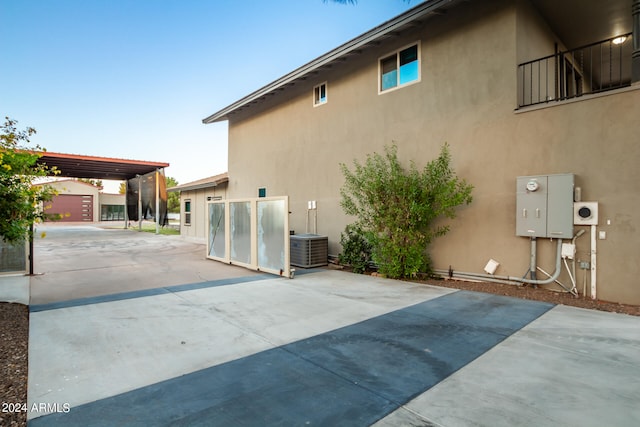 view of home's exterior with central AC unit and a carport