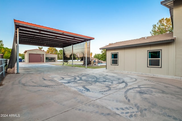 view of patio / terrace featuring a garage and an outbuilding