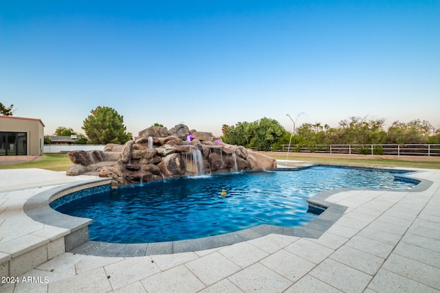 view of swimming pool with pool water feature