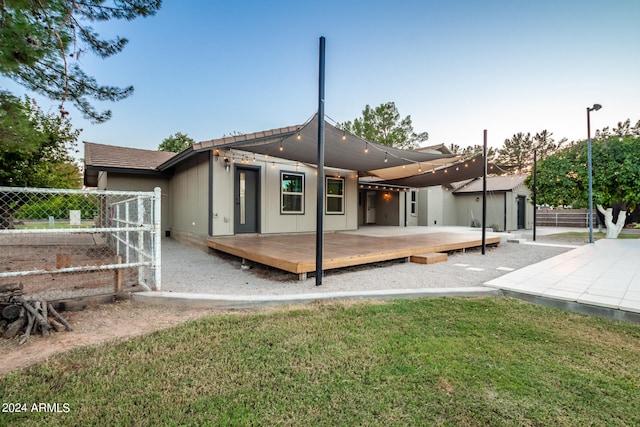 rear view of property featuring a lawn and a wooden deck