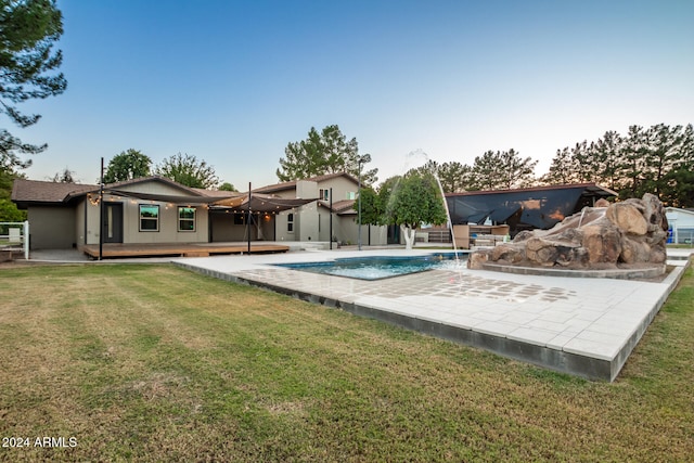 view of swimming pool featuring a yard, a deck, pool water feature, and a patio area