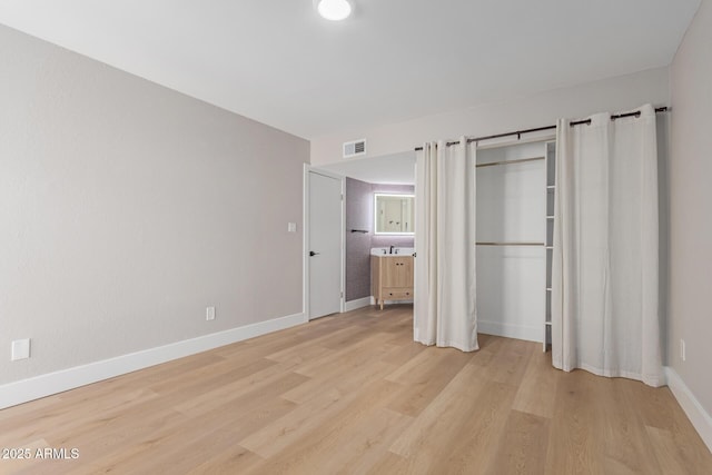 unfurnished bedroom with light wood-type flooring and baseboards