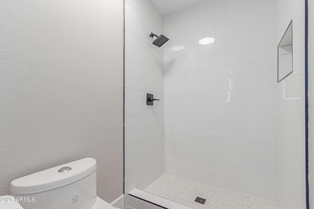 full bath with tiled shower and toilet