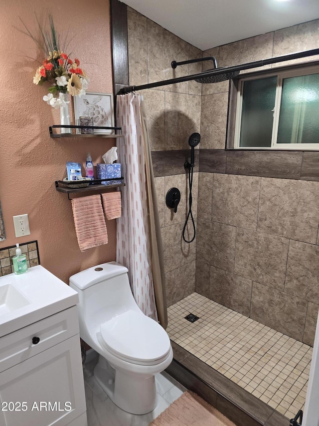 bathroom with a textured wall, vanity, a shower stall, and toilet