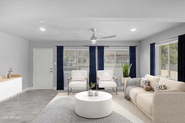 living area with recessed lighting, wood finished floors, a ceiling fan, and baseboards