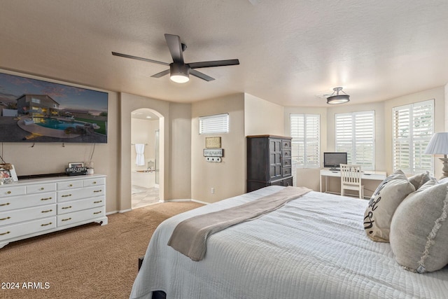 bedroom featuring light carpet, a textured ceiling, connected bathroom, and ceiling fan