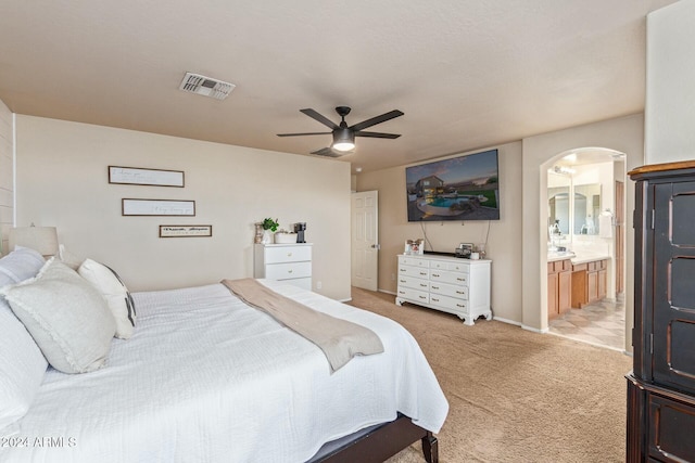 carpeted bedroom featuring ensuite bath and ceiling fan