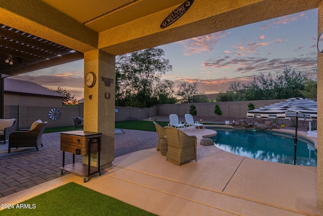 pool at dusk with a patio