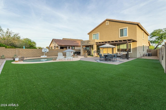 back of property featuring a lawn, a patio area, a fenced in pool, and central AC