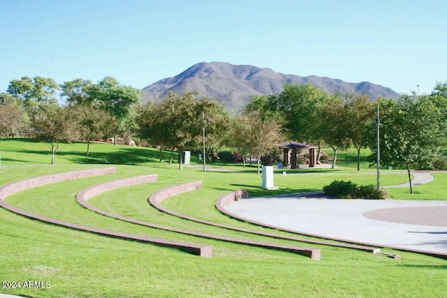 surrounding community with a mountain view and a yard