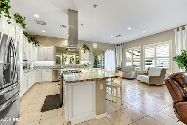 210 E Bergamot Ln, Queen Creek, AZ 85140 - kitchen featuring appliances with stainless steel finishes, light tile patterned flooring, a breakfast bar, light stone countertops, and white cabinets