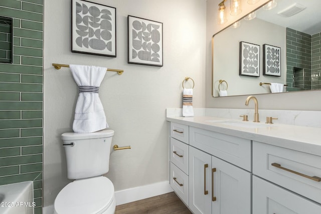 full bathroom with vanity, tiled shower / bath combo, wood-type flooring, and toilet