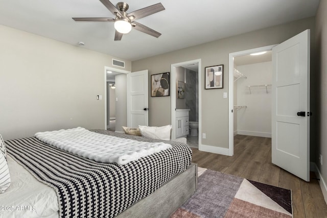 bedroom featuring a walk in closet, ensuite bathroom, dark hardwood / wood-style floors, and a closet