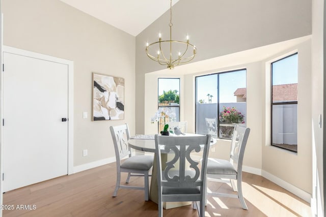 dining space featuring vaulted ceiling, a chandelier, and light wood-type flooring