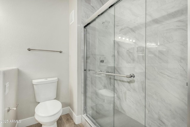 bathroom featuring wood-type flooring, an enclosed shower, and toilet