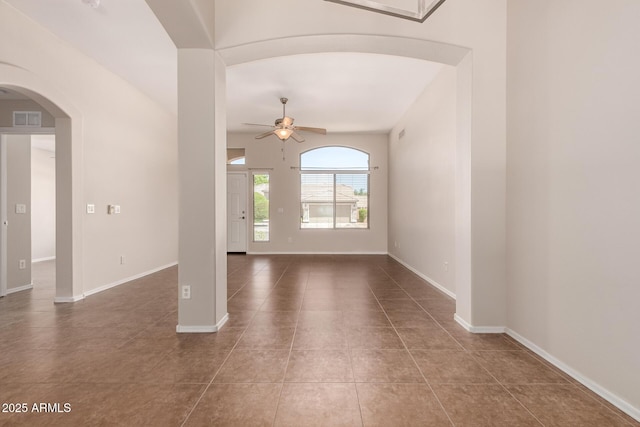 385 E Ironwood Dr, Chandler, AZ 85225 - unfurnished living room with arched walkways, ceiling fan, tile patterned flooring, and baseboards