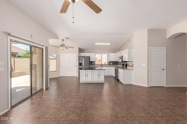 385 E Ironwood Dr, Chandler, AZ 85225 - unfurnished living room featuring a ceiling fan, vaulted ceiling, plenty of natural light, and dark tile patterned flooring