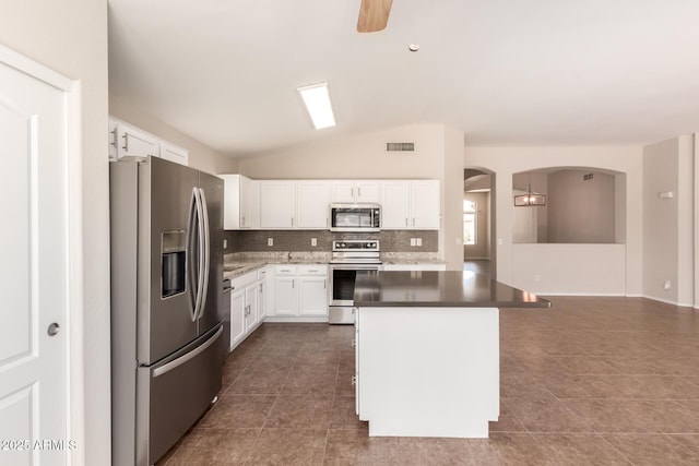 385 E Ironwood Dr, Chandler, AZ 85225 - kitchen featuring stainless steel appliances, vaulted ceiling, backsplash, arched walkways, and dark tile patterned floors