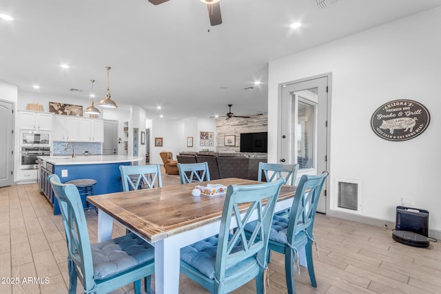 dining space featuring ceiling fan, sink, and light hardwood / wood-style floors