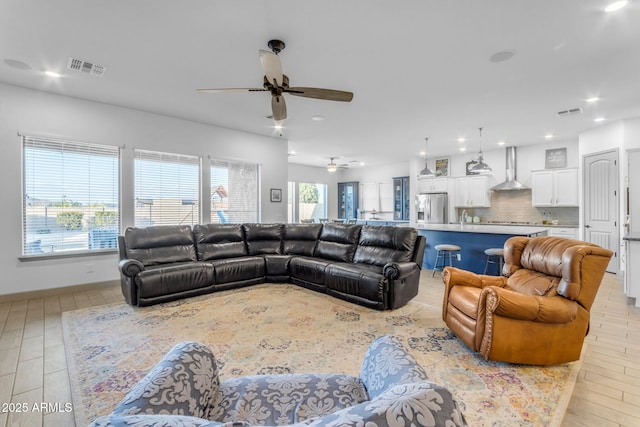 living room featuring ceiling fan, sink, and light hardwood / wood-style flooring