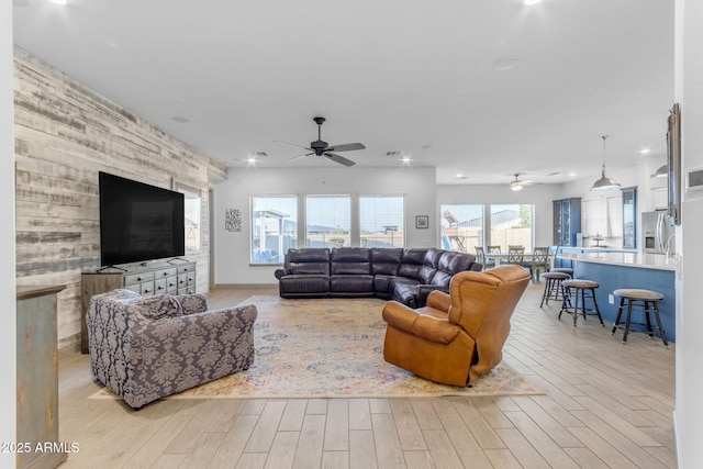 living room with ceiling fan and light wood-type flooring