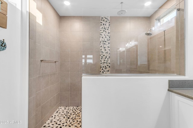 bathroom featuring vanity and a tile shower