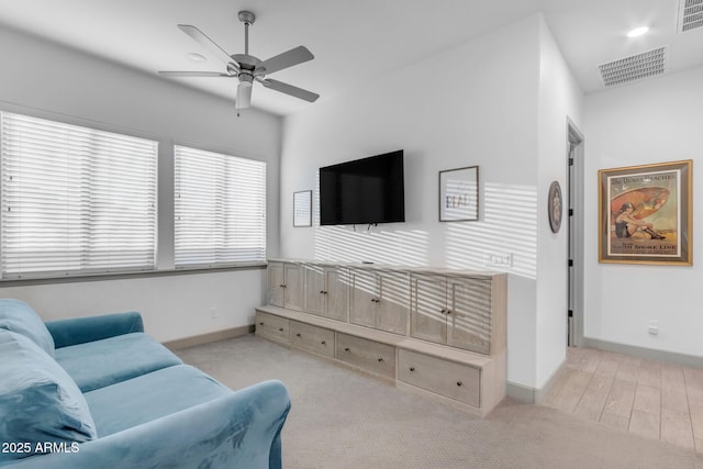 living room with ceiling fan and light hardwood / wood-style flooring