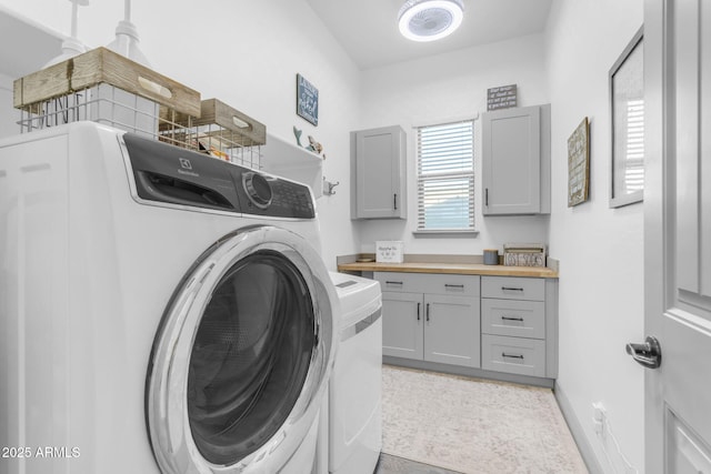 washroom featuring washing machine and dryer and cabinets