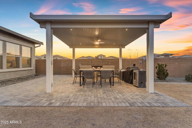 patio terrace at dusk with ceiling fan and a grill