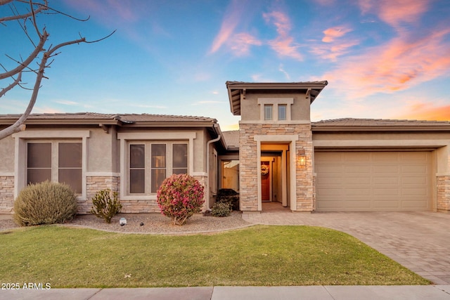 prairie-style house featuring a garage and a lawn