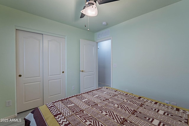 unfurnished bedroom with ceiling fan, a closet, and light wood-type flooring