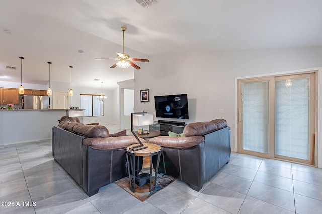 living room featuring ceiling fan with notable chandelier, lofted ceiling, and light tile patterned floors