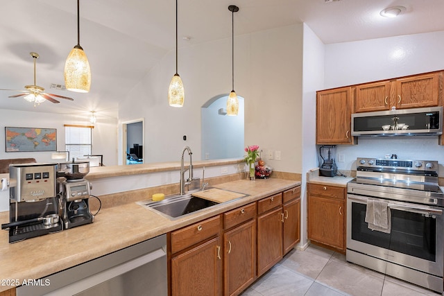 kitchen with appliances with stainless steel finishes, lofted ceiling, sink, hanging light fixtures, and ceiling fan