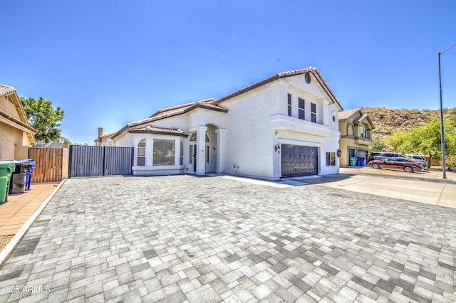 1853 N Rowen Cir, Mesa, AZ 85207 - mediterranean / spanish home with driveway, a garage, stucco siding, a tiled roof, and a gate