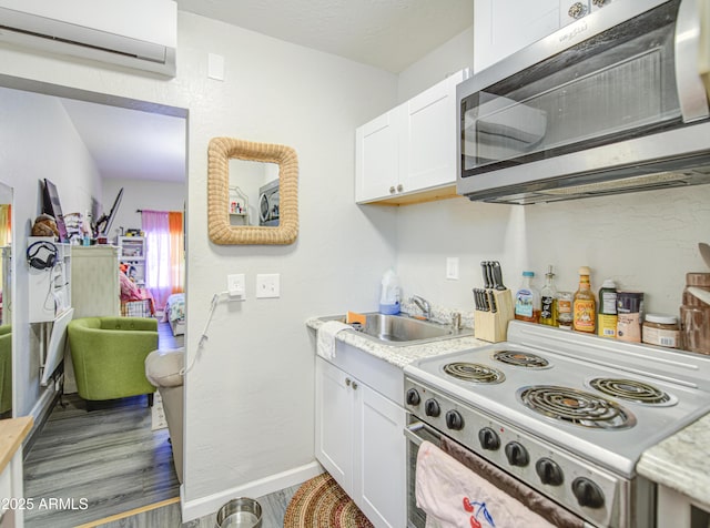 1853 N Rowen Cir, Mesa, AZ 85207 - kitchen featuring stainless steel microwave, white electric range, a wall unit AC, light countertops, and white cabinetry