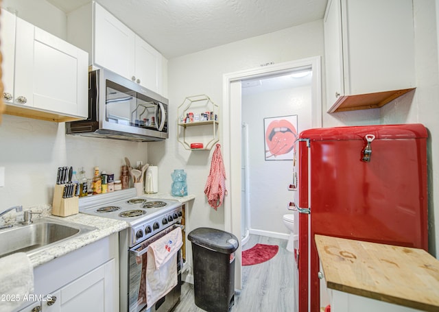 1853 N Rowen Cir, Mesa, AZ 85207 - kitchen with stainless steel microwave, electric stove, wood finished floors, white cabinets, and a textured ceiling