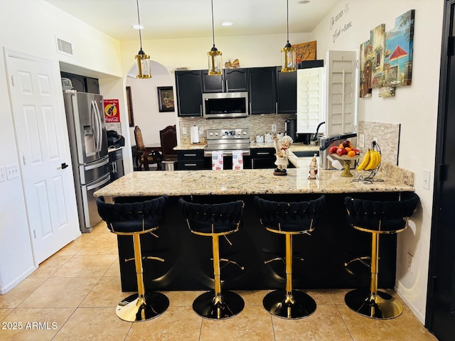 1853 N Rowen Cir, Mesa, AZ 85207 - kitchen with stainless steel appliances, a peninsula, a kitchen breakfast bar, and decorative backsplash