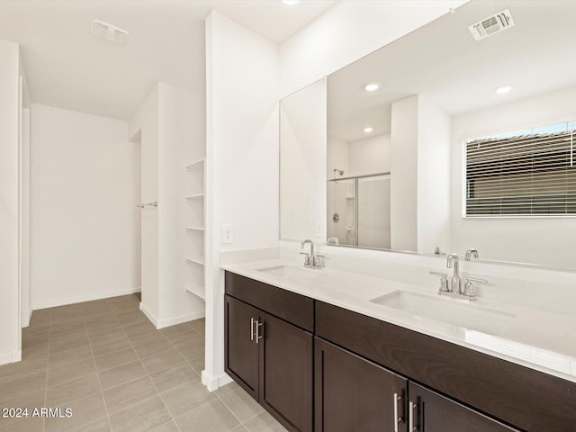 bathroom featuring vanity, a shower with shower door, and tile patterned floors