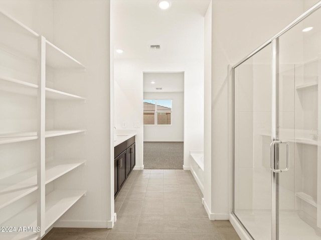 bathroom with tile patterned floors, vanity, and shower with separate bathtub