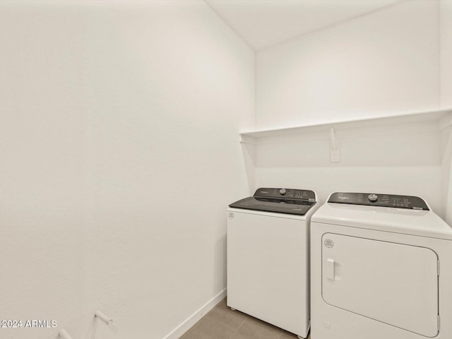 laundry room with light tile patterned flooring and washer and clothes dryer