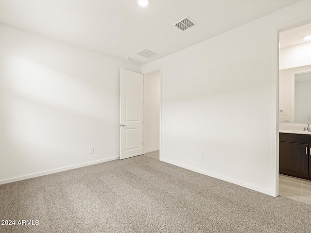 unfurnished room with sink and light colored carpet