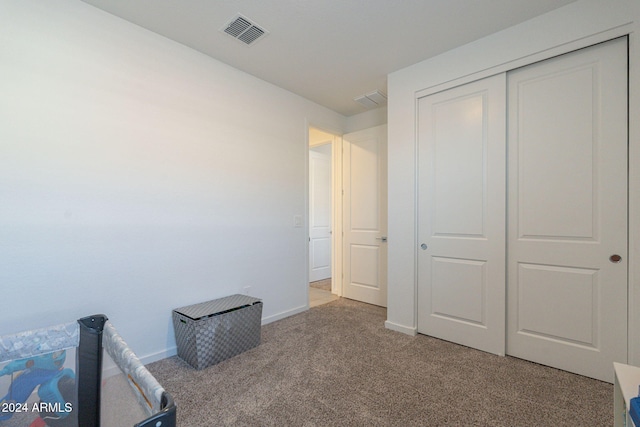 unfurnished bedroom featuring light carpet and a closet