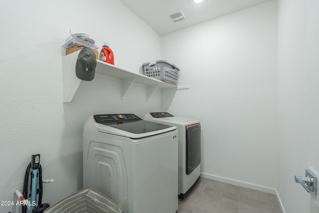 laundry room with washer and clothes dryer and light tile patterned floors