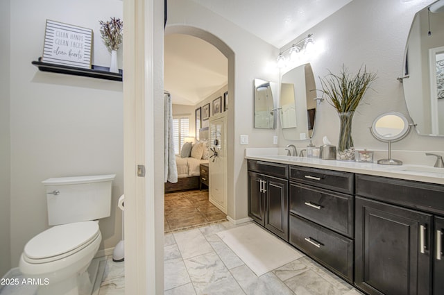 1217 S Longmore Ct, Chandler, AZ 85286 - ensuite bathroom featuring double vanity, marble look tiles, toilet, and baseboards