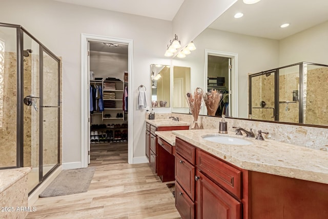 bathroom featuring hardwood / wood-style flooring, vanity, and a shower with shower door